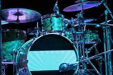 Fototapeta na wymiar Backlighted drum set with bass drum, tom-toms, cymbals and microphones