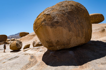 Woman explores giant balanced rocks, Erongo Mountains, Namibia