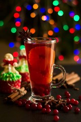 Christmas decoration. Cup of mulled wine and christmas cupcakes on bokeh background. Selective focus