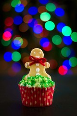 Christmas cupcakes with christmas tree shape and gingerbread men on bokeh background. Selective focus