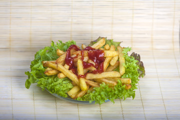 Fresh fried french fries with ketchup on wooden background