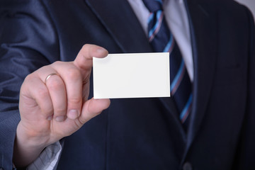 A businessman in a suit showing a business card