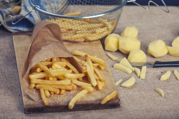 Fresh fried french fries with ketchup on wooden background