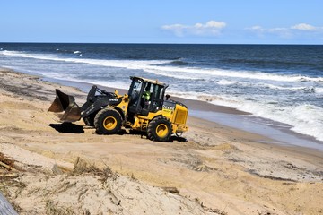 Fork lift clearing beach of debris caused by Hurricane Matthew hitting the east coast of Florida, USA