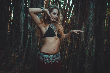 Girl in ethnic dress dancing on the background of the sacred banyan