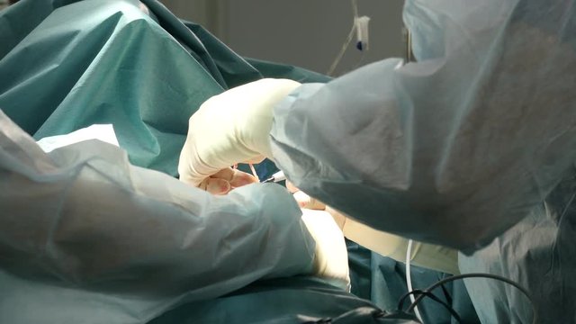 Surgery. Surgeon hands during operation in surgical room