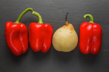 Paprika and pear. In natural stone, background.