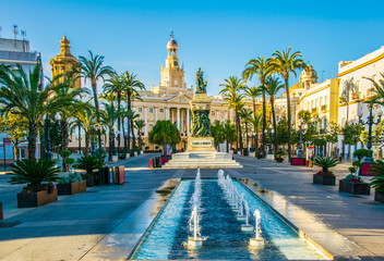 View of a fountain situated on the square of saint john of god in cadiz with town hall on background - obrazy, fototapety, plakaty