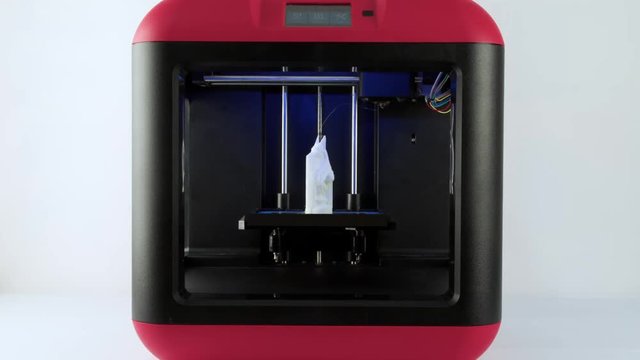 Working 3D printer isolated on white background 4k video. Printing three dimensional model: object done. Additive manufacturing device machine technology concept