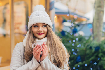 beautiful woman with blue eyes drinks hot wine on christmas mark