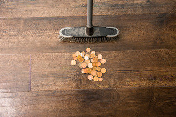 looking after your savings broom sweeping up coins on floor