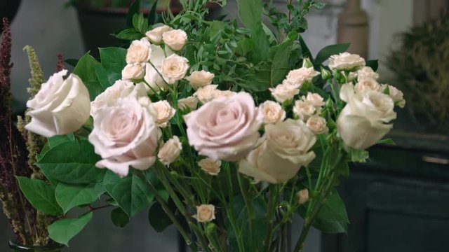 Closeup of bouquets of white chrysanthemums and roses in flower shop