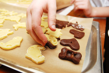children's hands making christmas cookies with metal cutter.