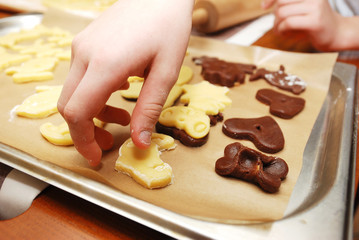 children's hands making christmas cookies with metal cutter.