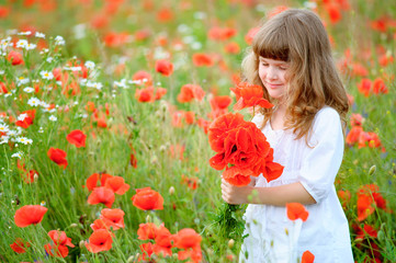Obraz na płótnie Canvas Sweet little girl pick a flowers in a wild meadow with poppies a