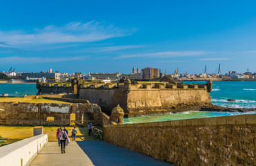 view of the castle of san sebastian with city of cadiz on background