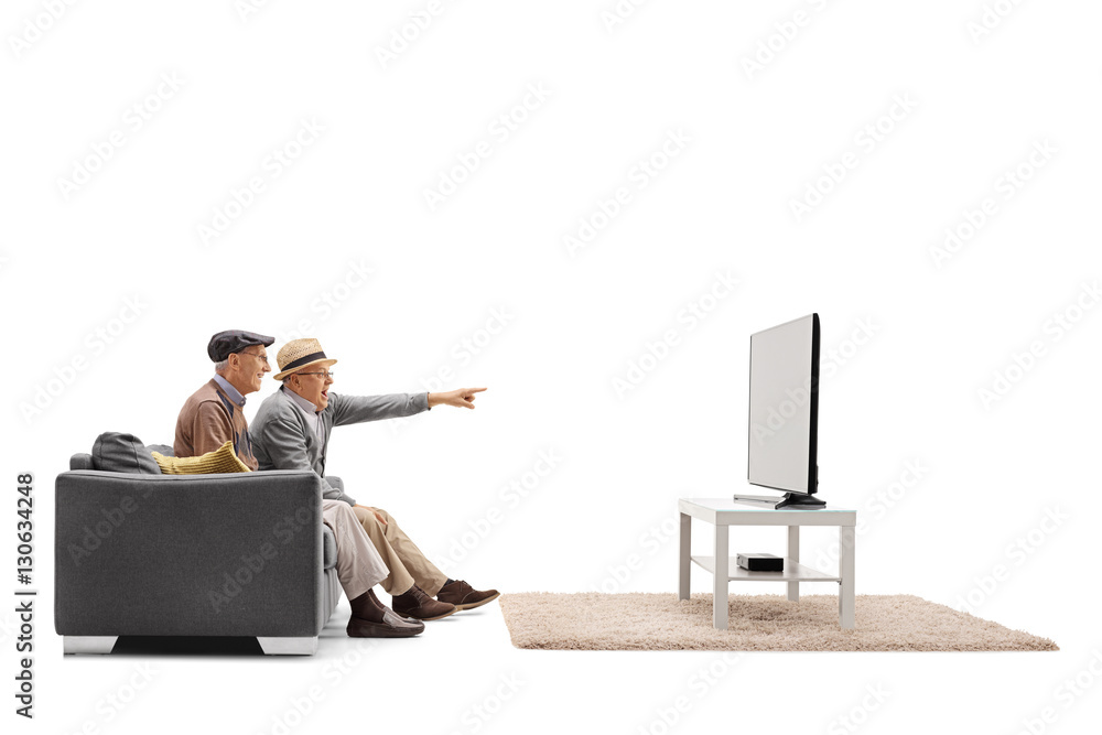 Poster two mature men on a sofa and watching television with one of the pointing with his finger