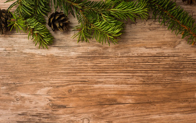 rustic christmas wooden background with pine (christmas tree) branches and cones