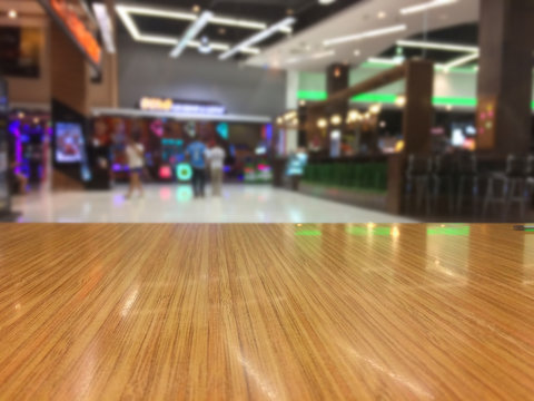 Wooden table display with shopping mall view.Blur background. Mobile photography