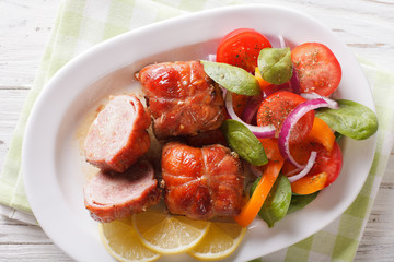 Baked rabbit fillet and salad of tomatoes, peppers, spinach and onion close-up. horizontal top view