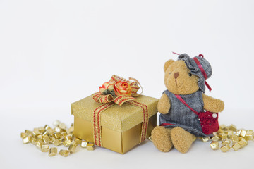 Teddy bear with gold color gift box on white background