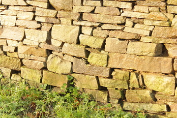 a stone wall made out of big stone light brown bricks outdoor