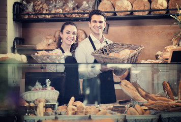 Adult couple selling pastry and loaves