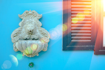 Lion head model is art ,Carve for cement on blue wall background with lighting flare effect.