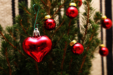 Red heart and a few balls on the Christmas tree