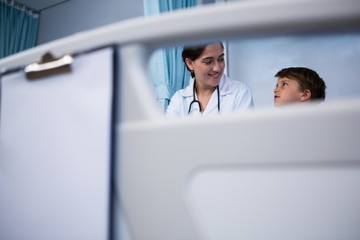 Doctor interacting with patient in ward at hospital