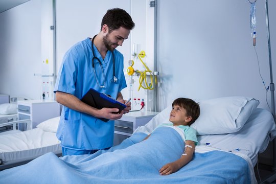 Male nurse interacting with patient during visit in ward