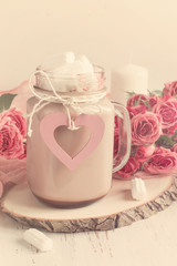 Cocoa with marshmallows and a bouquet of roses.