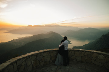 honeymoon couple kiss and embrace at sunset