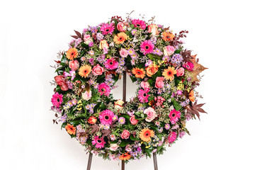 Colorful flower arrangement wreath for funerals isolated on white background