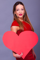 Woman wearing red dress holding big heart sign love symbol