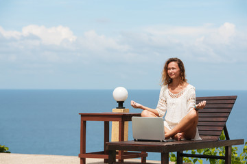 Young woman in white dress doing online shopping outdoors. Stock image.