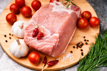 Raw pork on cutting board and vegetables 