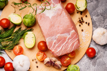 Raw pork on cutting board and vegetables 