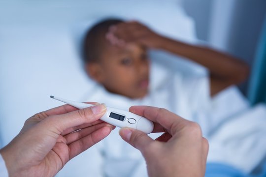 Hand of checking patient fever during visit in ward