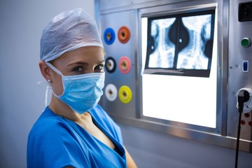 Fototapeta premium Portrait of female nurse examining x-ray on lightbox