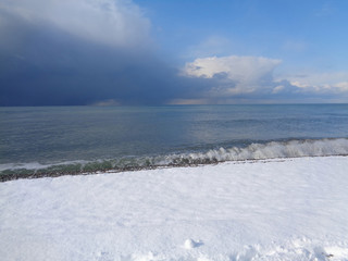 Snow on the coast and storm clouds over the sea