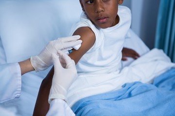 Doctor giving an injection to patient in ward