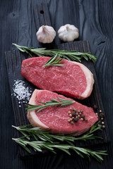 Raw fresh beef medallion steaks over black wooden background