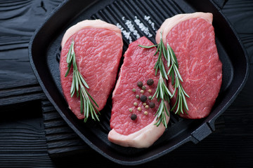 Cast-iron grill pan with fresh uncooked beef medallions