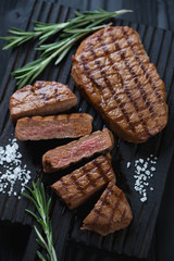Close-up of whole and sliced grilled beef medallion steaks
