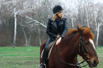 Obraz premium girl smiling while sitting on a horse in the forest