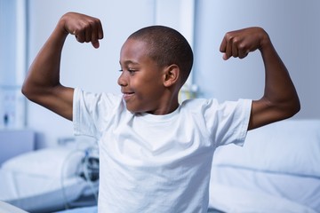Boy flexing his muscles in ward