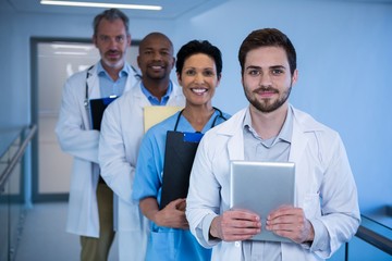 Portrait of male doctors and nurse standing in corridor