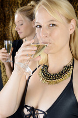 Frau im Abendkleid trinkt Sekt oder Champagner auf Party oder Feier zu Silvester