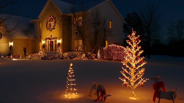 Special holiday decorated home with evening Christmas lights, fluffy snow
